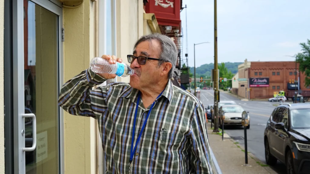 a man drinking water outside of the allentown rescue mission in pennsylvania